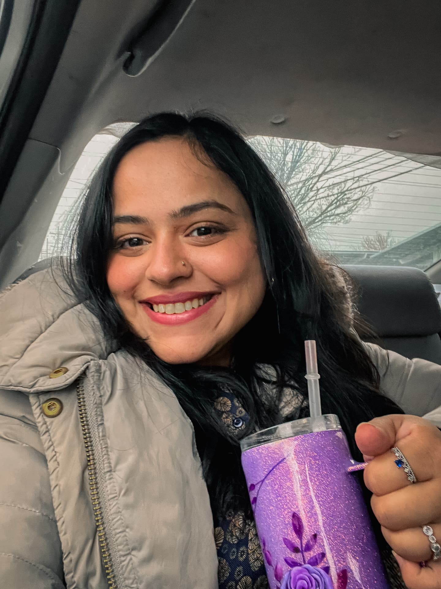 Gul-e Rana with a coffee tumbler in the car